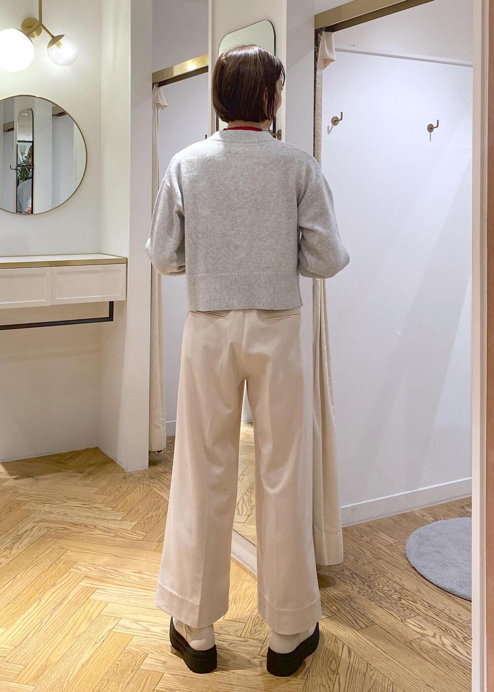 ホワイト系のブーツ、グレー系のカーディガン/ボレロ、レッド系のニット/セーターを着用したレディースの冬コーディネートの9枚目の写真