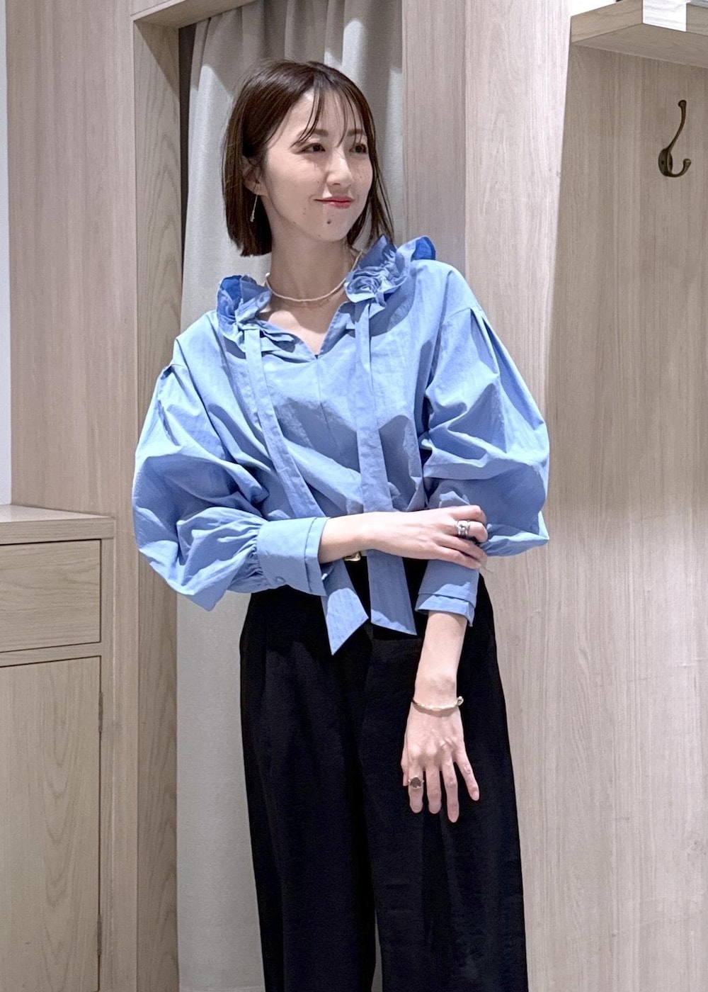 ホワイト系のショルダーバッグ、ブルー系のシャツ/ブラウス、ホワイト系のパンプスを着用したレディースの春コーディネートの6枚目の写真