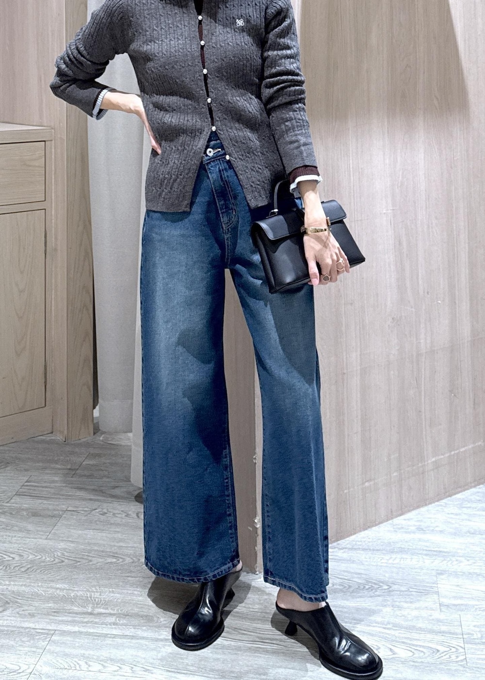 ブラック系のショルダーバッグ、ブルー系のデニムパンツ、グレー系のブルゾンを着用したレディースの冬コーディネートの8枚目の写真