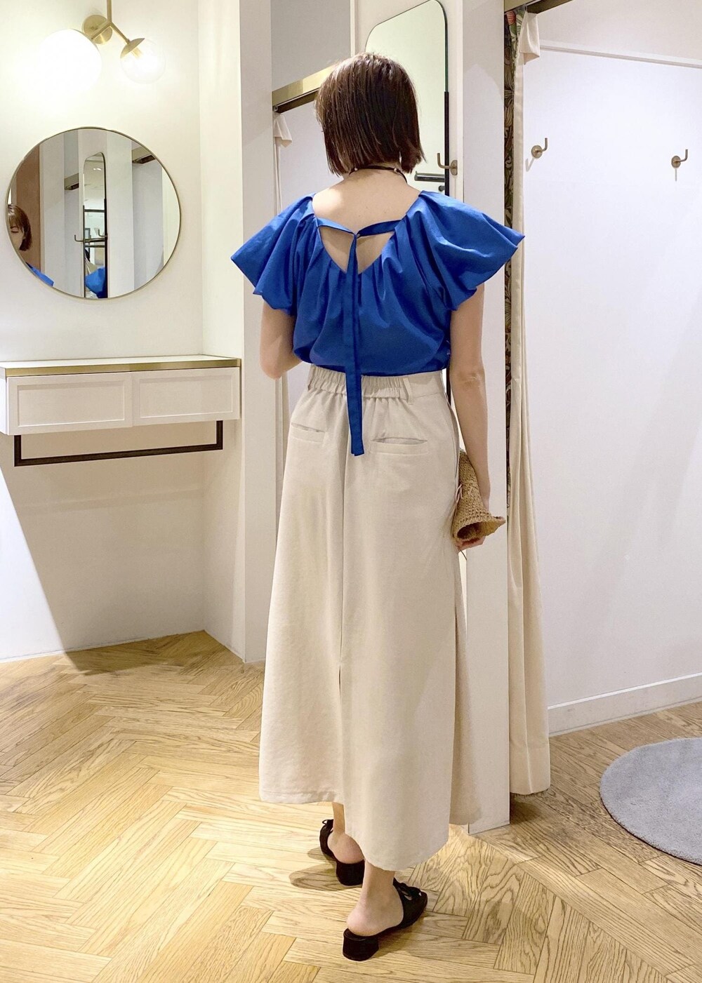 ブラック系のキャミソール、ブラック系のサンダル、ホワイト系のスカートを着用したレディースの春コーディネートの3枚目の写真