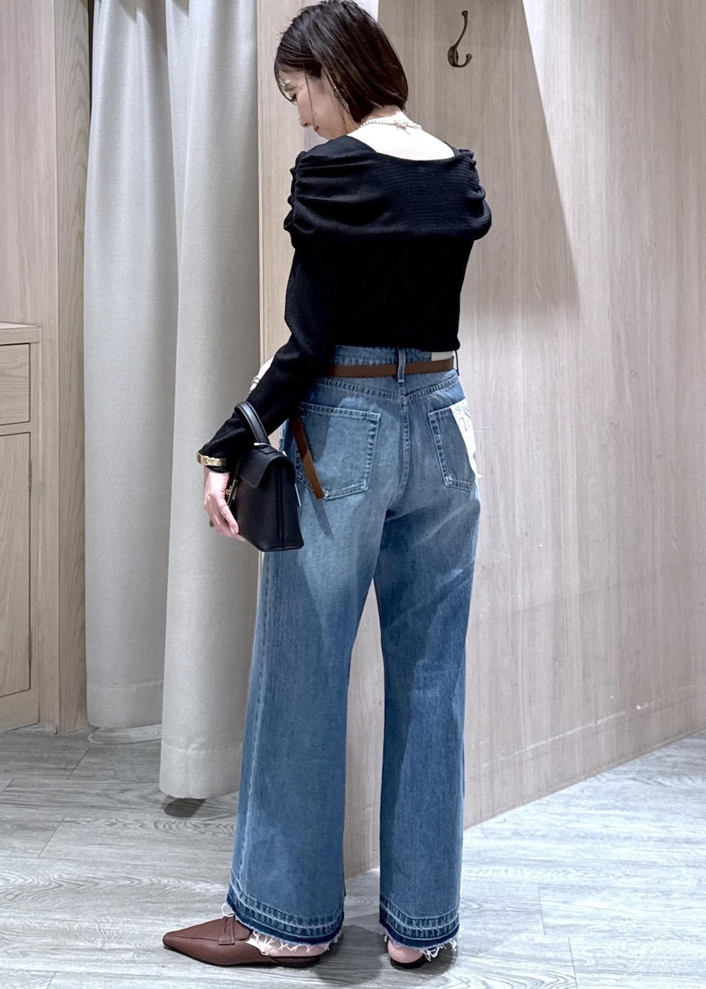 ブラック系のショルダーバッグ、ブルー系のデニムパンツ、ブラック系のTシャツ/カットソーを着用したレディースの春コーディネートの5枚目の写真