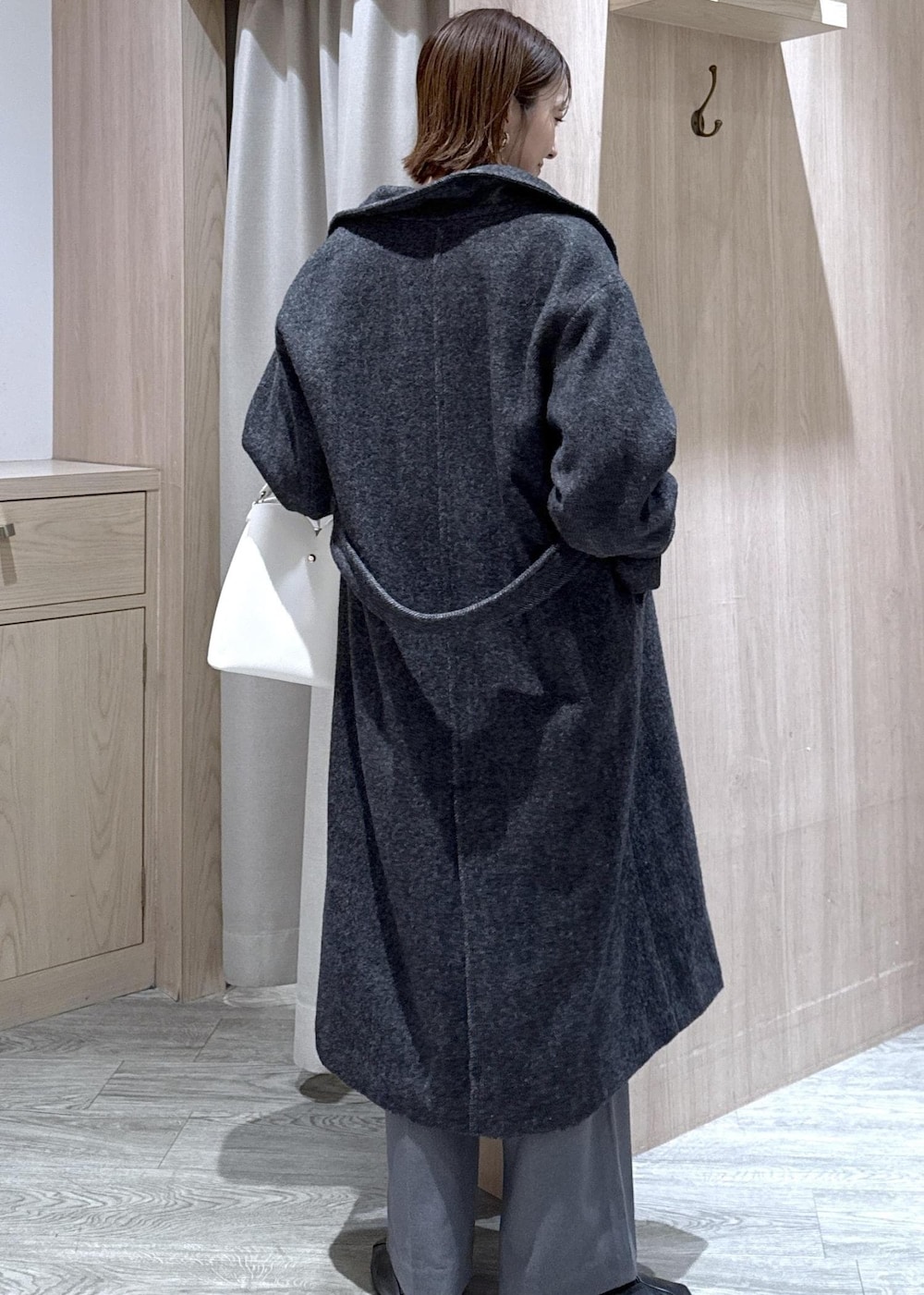 ホワイト系のショルダーバッグ、ブルー系のカーディガン/ボレロ、グレー系のその他アウターを着用したレディースの冬コーディネートの4枚目の写真