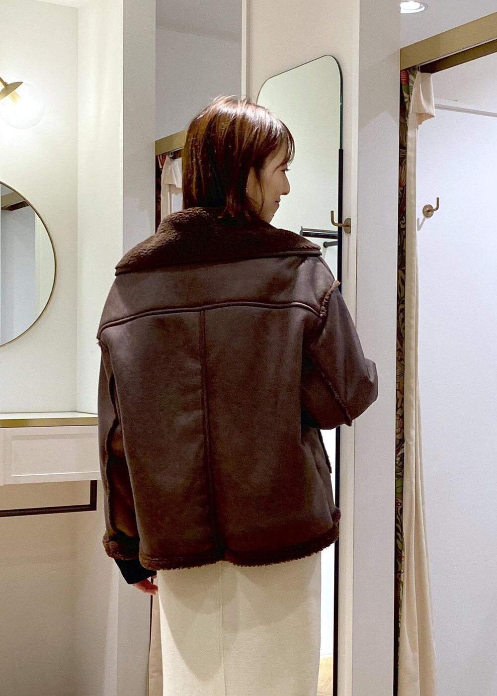 ブラック系のショルダーバッグ、ブラウン系のブーツ、ブラック系のニット/セーターを着用したレディースの秋コーディネートの6枚目の写真