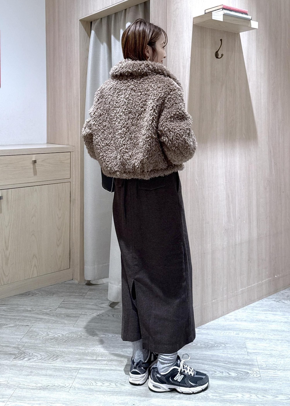 ブラウン系のスカート、ブラウン系のブルゾン、ホワイト系のスウェットを着用したレディースの秋コーディネートの5枚目の写真