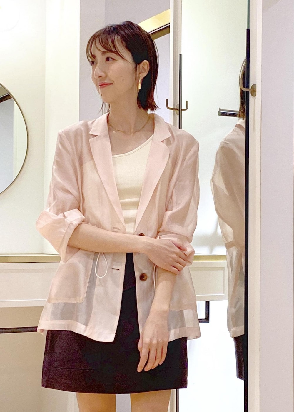 ホワイト系のタンクトップ、ブラック系のショルダーバッグ、ブラック系のサンダルを着用したレディースの春コーディネートの4枚目の写真