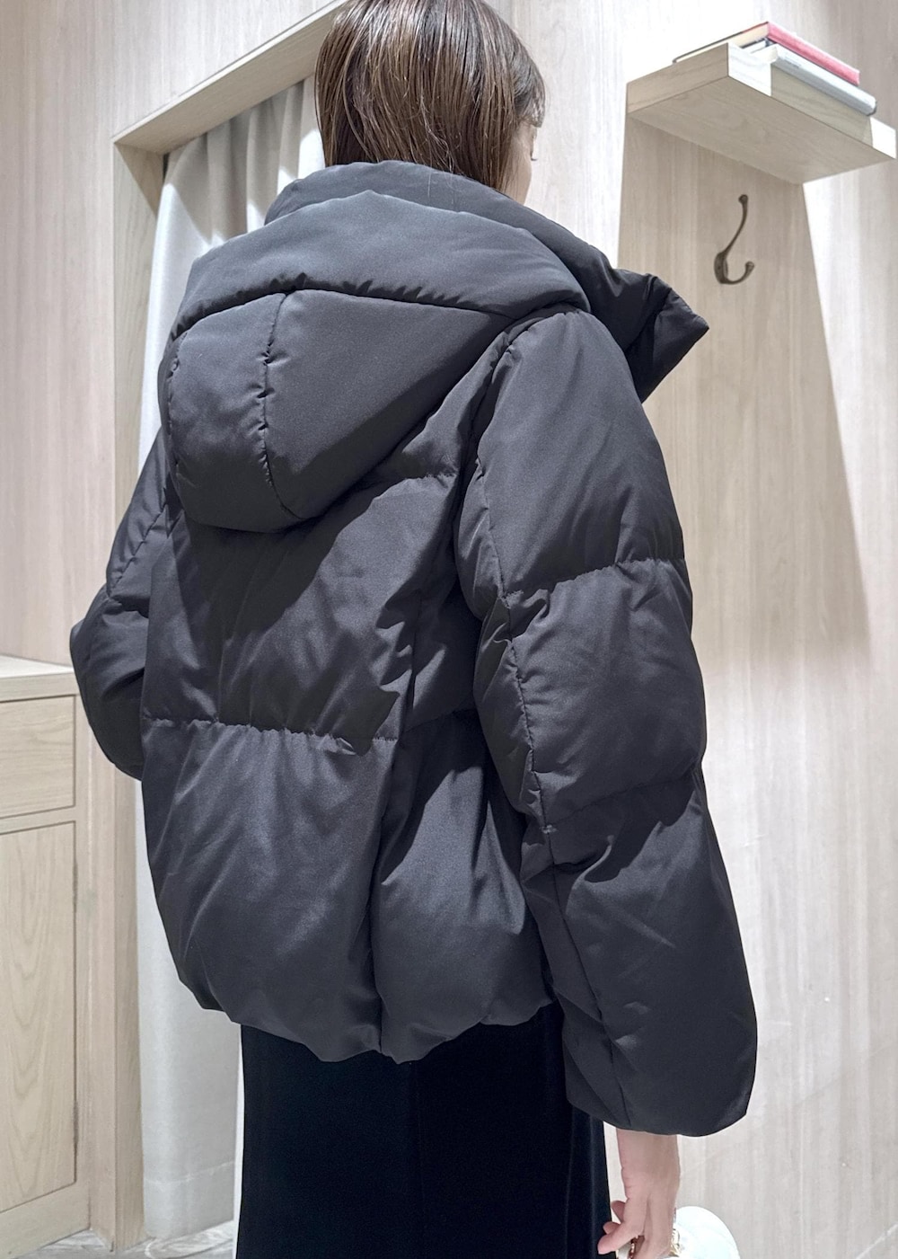 ブラック系のブーツ、ブラック系のスカート、ブラック系のダウンジャケット/コートを着用したレディースの冬コーディネートの10枚目の写真