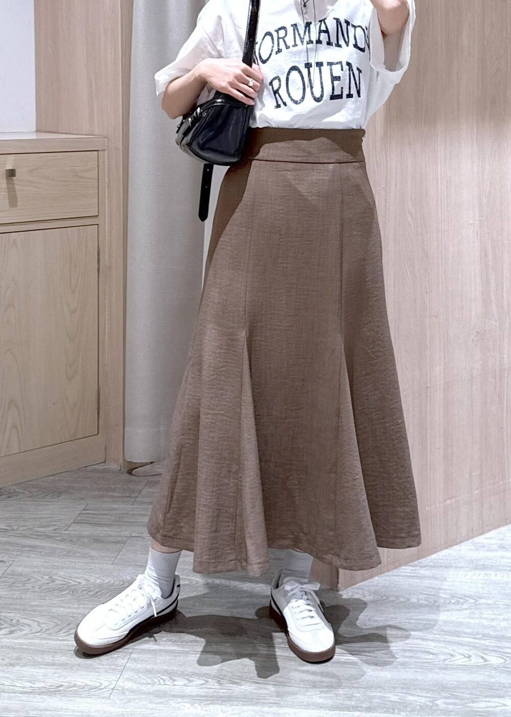 グリーン系のスカート、ホワイト系のTシャツ/カットソー、ブラック系のハンドバッグを着用したレディースの春コーディネートの7枚目の写真