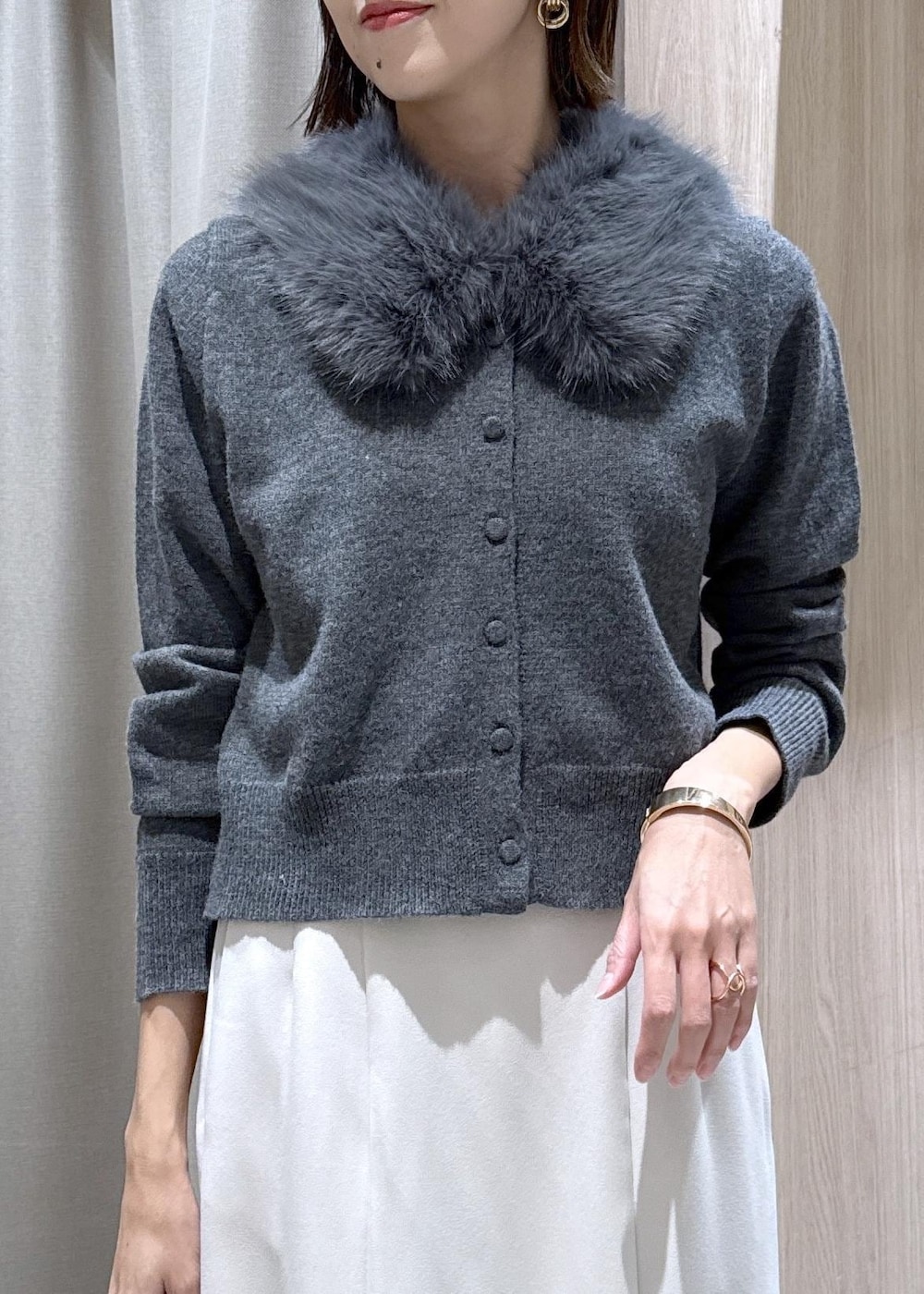 シルバー系のパンプス、ホワイト系のキャミソール、ホワイト系のスカートを着用したレディースの冬コーディネートの4枚目の写真