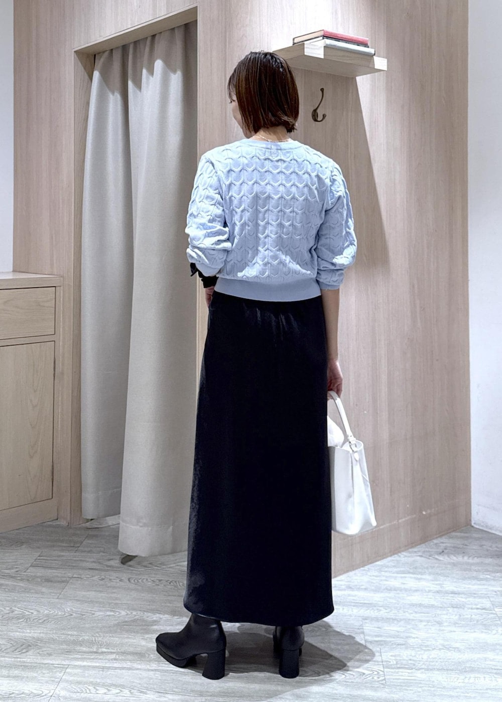 ホワイト系のショルダーバッグ、ホワイト系のキャミソール、ブラック系のブーツを着用したレディースの秋コーディネートの5枚目の写真