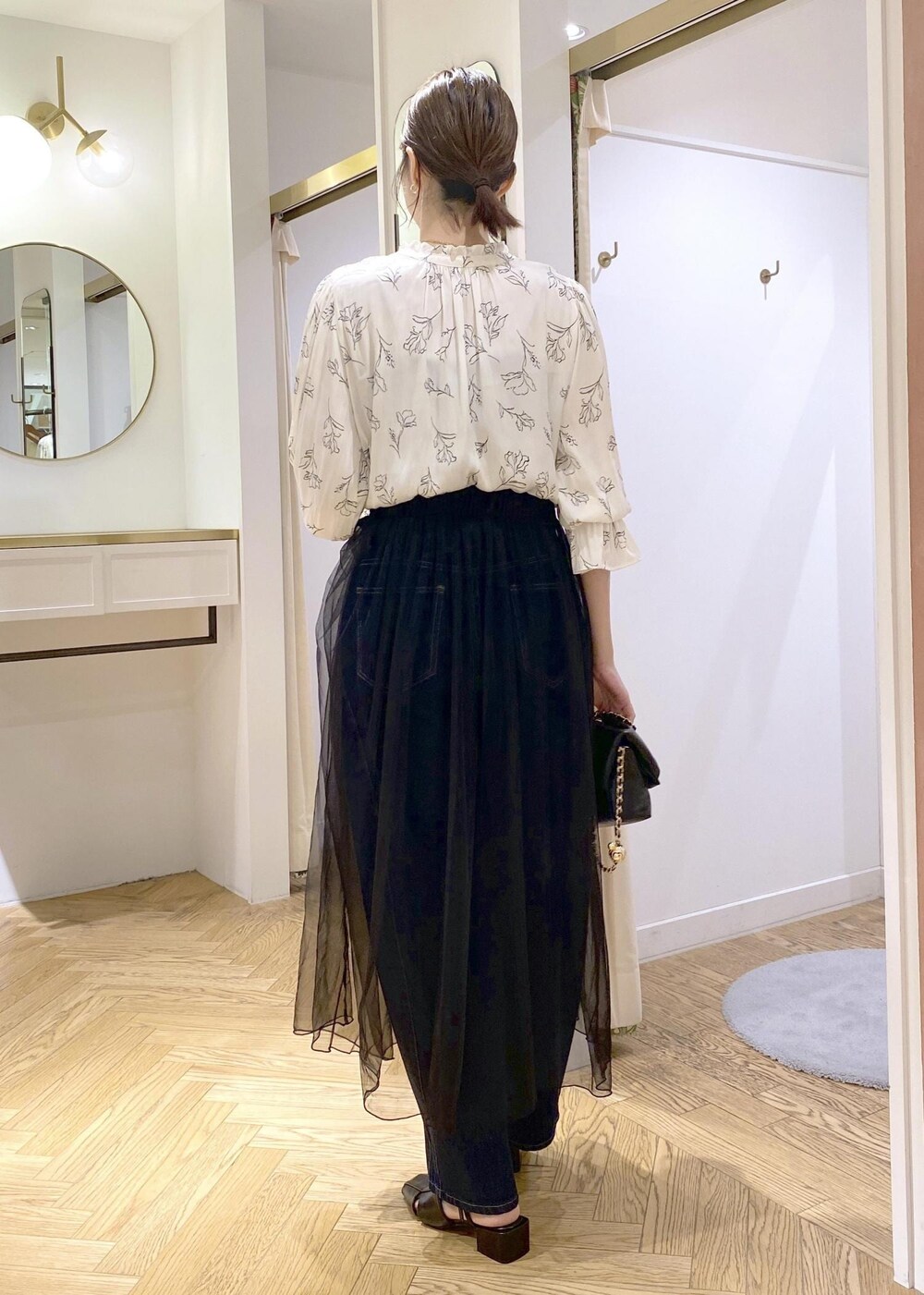 ブラック系のサンダル、ブラック系のスカート、ホワイト系のシャツ/ブラウスを着用したレディースの春コーディネートの2枚目の写真