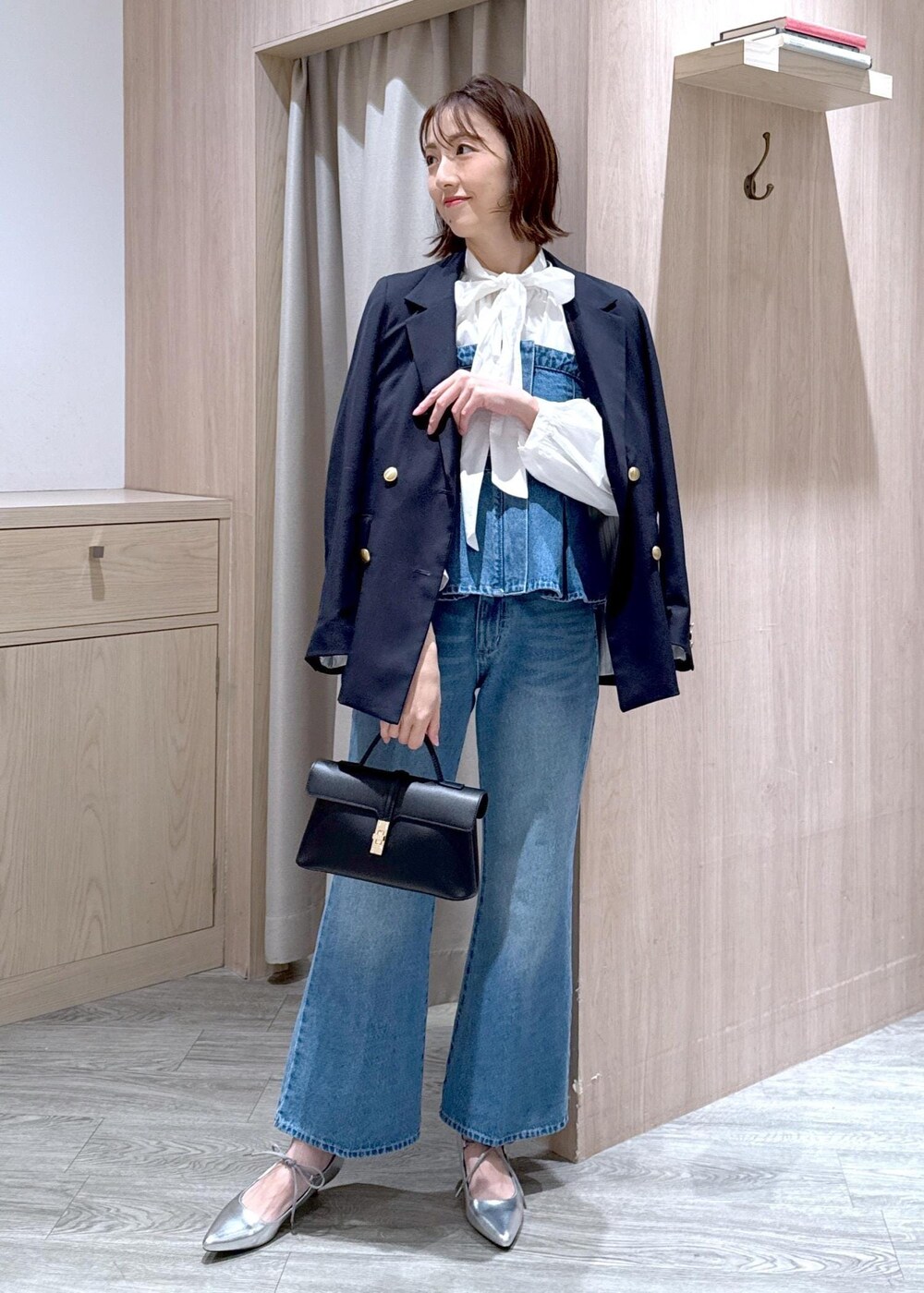 ブラック系のショルダーバッグ、ブルー系のキャミソール、ブルー系のテーラードジャケットを着用したレディースの冬コーディネートの10枚目の写真