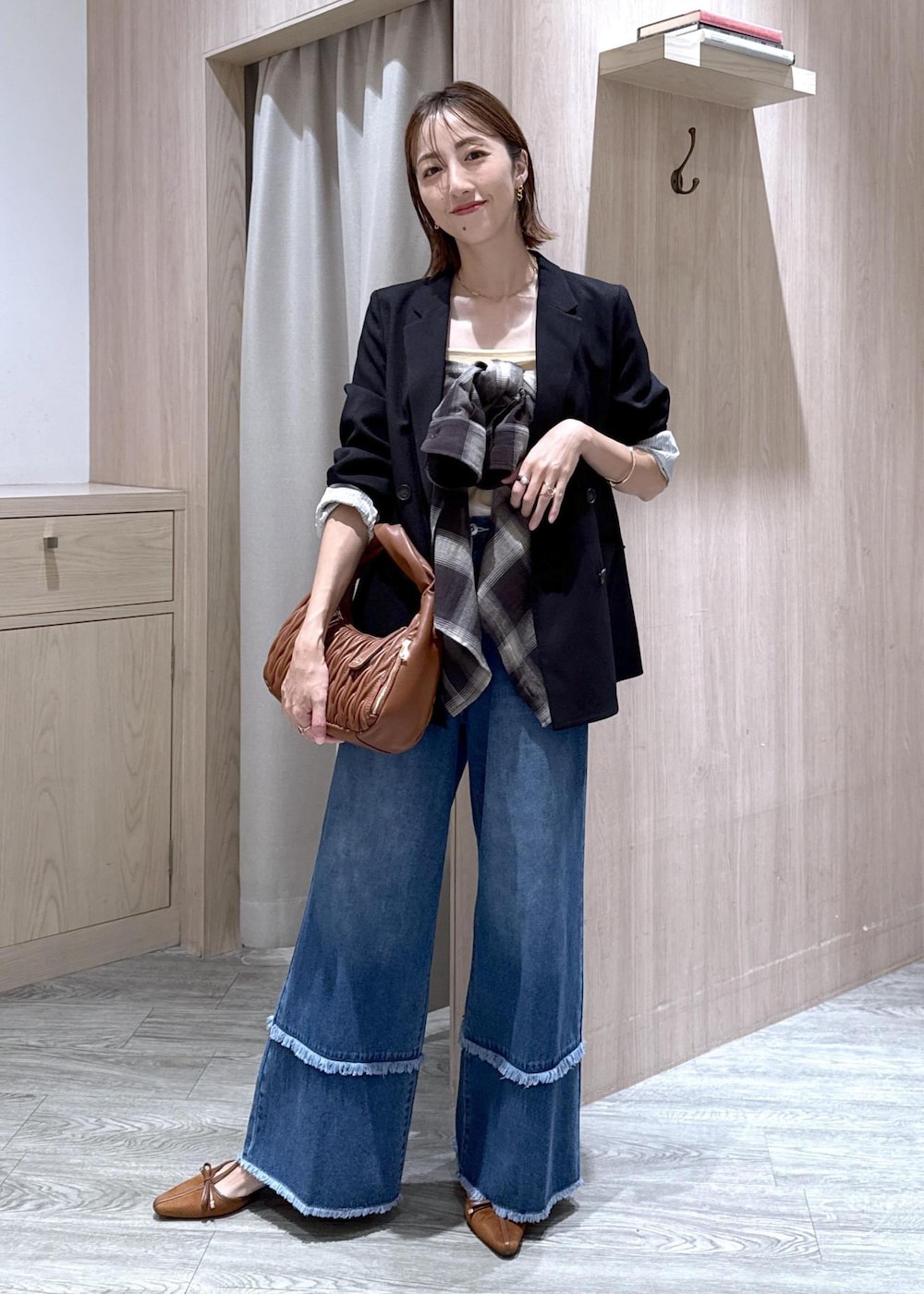 ブルー系のデニムパンツ、ブラック系のシャツ/ブラウス、イエロー系のパンプスを着用したレディースの秋コーディネートの2枚目の写真