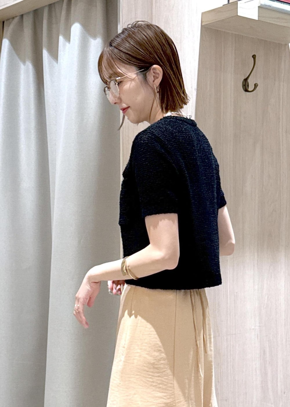 ブラック系のパンプス、オレンジ系のスカート、ブラック系のハンドバッグを着用したレディースの春コーディネートの10枚目の写真