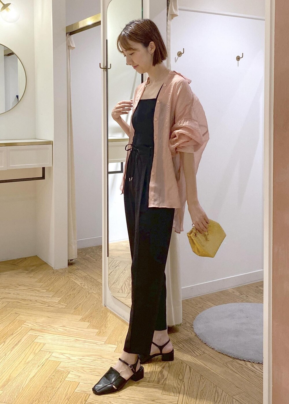 ブラック系のサンダル、ブラック系のスラックス、ブラック系のキャミソールを着用したレディースの夏コーディネートの2枚目の写真