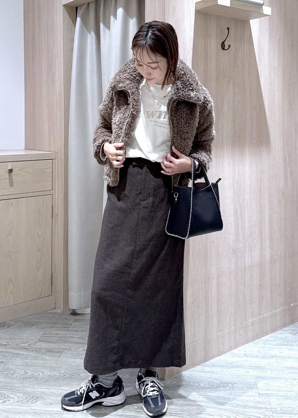 ブラウン系のスカート、ブラウン系のブルゾン、ホワイト系のスウェットを着用したレディースの秋コーディネートの3枚目の写真