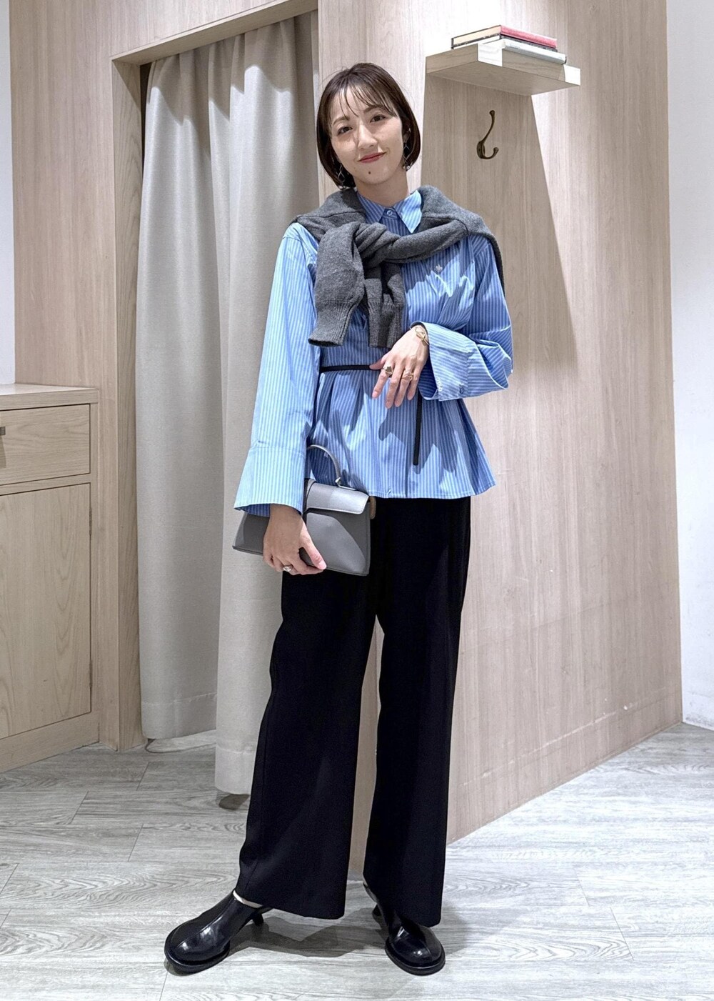 グレー系のショルダーバッグ、ブラック系のスラックス、グレー系のカーディガン/ボレロを着用したレディースの秋コーディネートの10枚目の写真