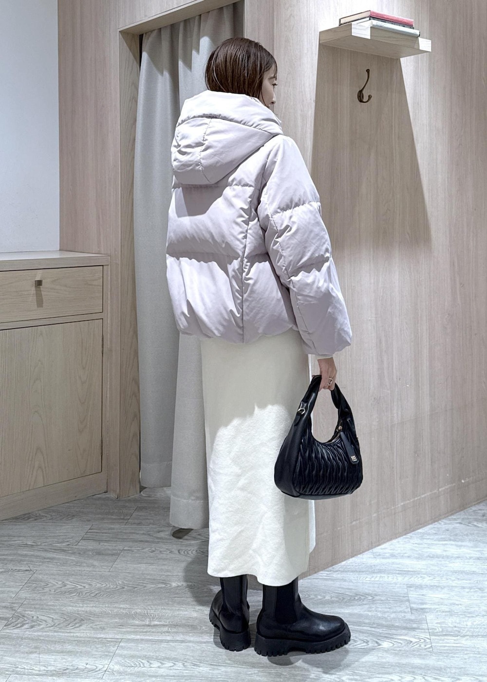 ブラック系のハンドバッグ、ピンク系のダウンジャケット/コート、ホワイト系のワンピースを着用したレディースの冬コーディネートの5枚目の写真