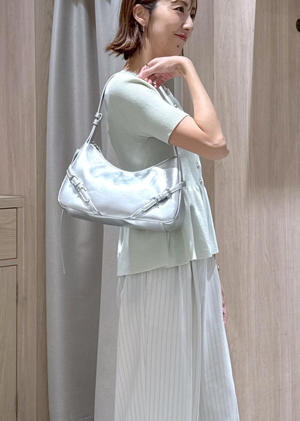 シルバー系のパンプス、グリーン系のカーディガン/ボレロ、ホワイト系のその他パンツを着用したレディースの夏コーディネートの5枚目の写真