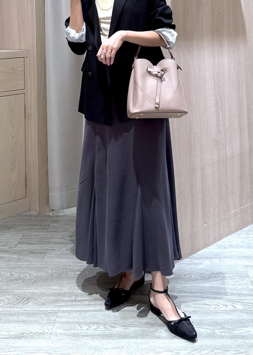 ブラック系のパンプス、ブラック系のテーラードジャケット、ベージュ系のショルダーバッグを着用したレディースの秋コーディネートの5枚目の写真