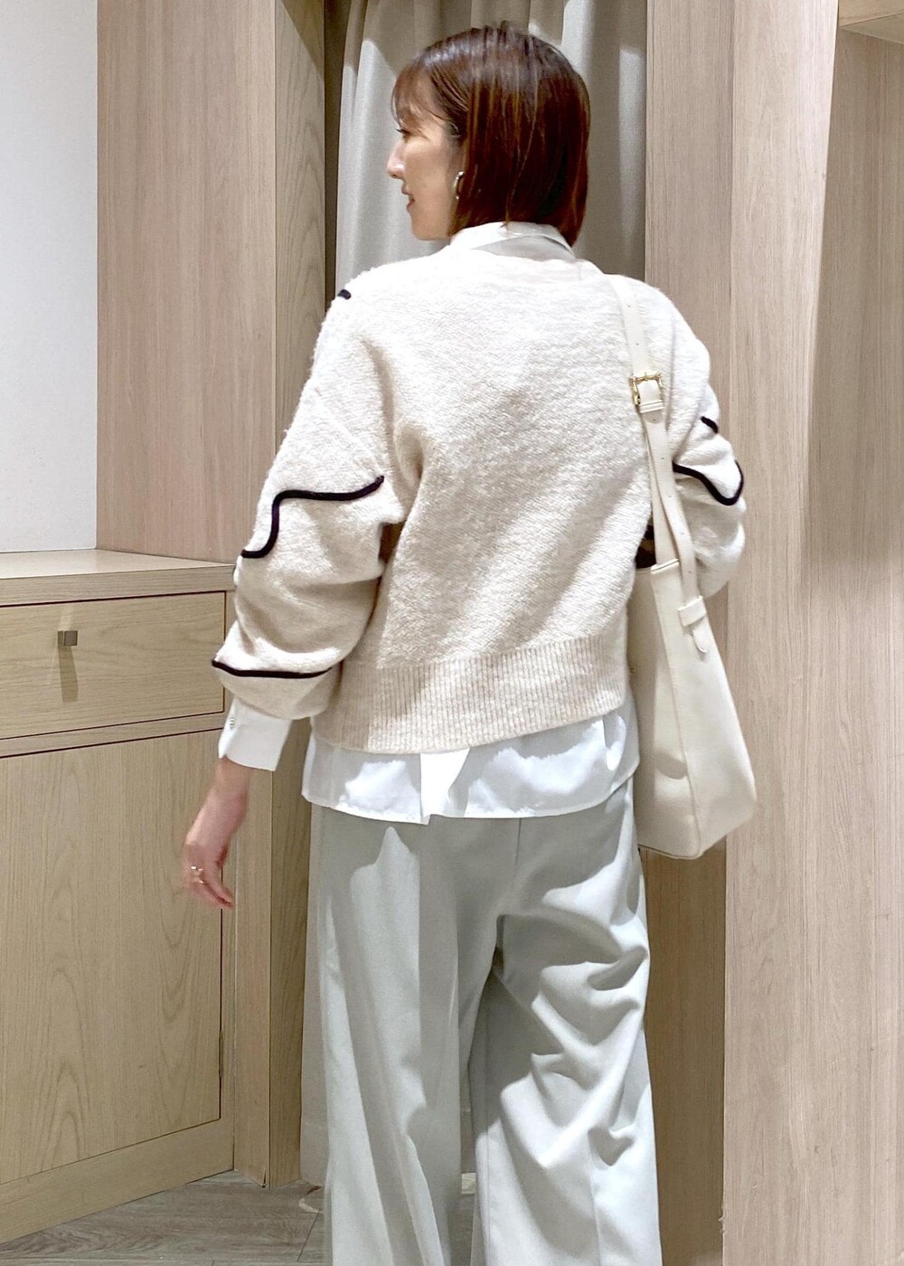 ホワイト系のトートバッグ、ホワイト系のニット/セーター、ホワイト系のシャツ/ブラウスを着用したレディースの冬コーディネートの7枚目の写真
