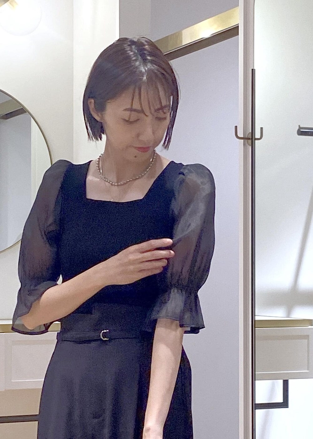 ブラック系のパンプス、ブラック系のショルダーバッグ、ブラック系のスラックスを着用したレディースの夏コーディネートの4枚目の写真