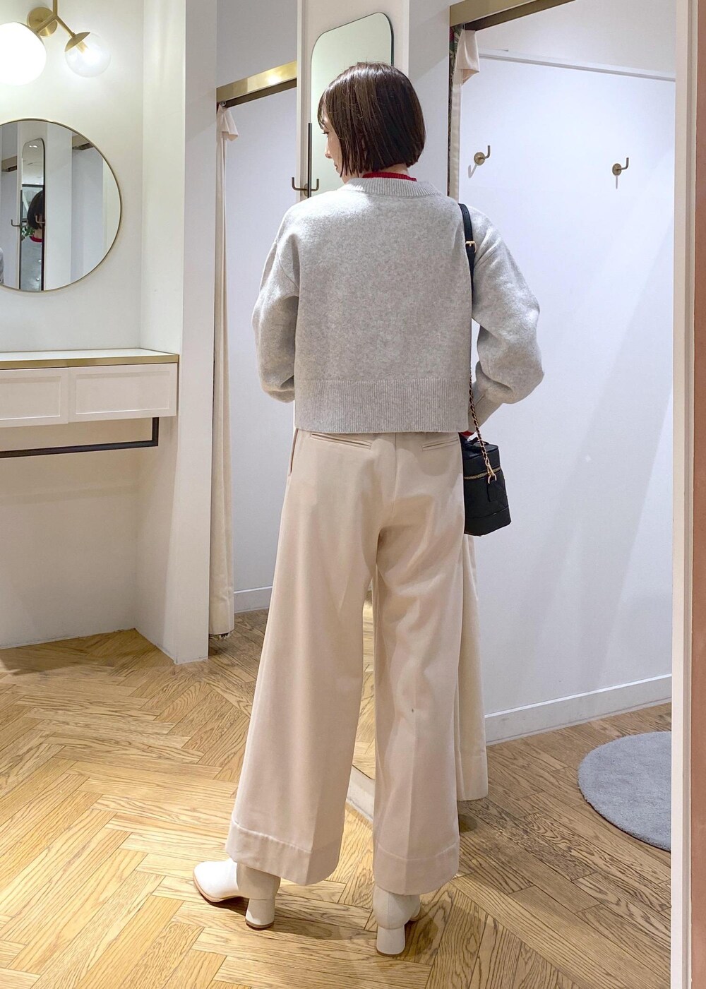 ホワイト系のブーツ、グレー系のカーディガン/ボレロ、レッド系のニット/セーターを着用したレディースの冬コーディネートの3枚目の写真