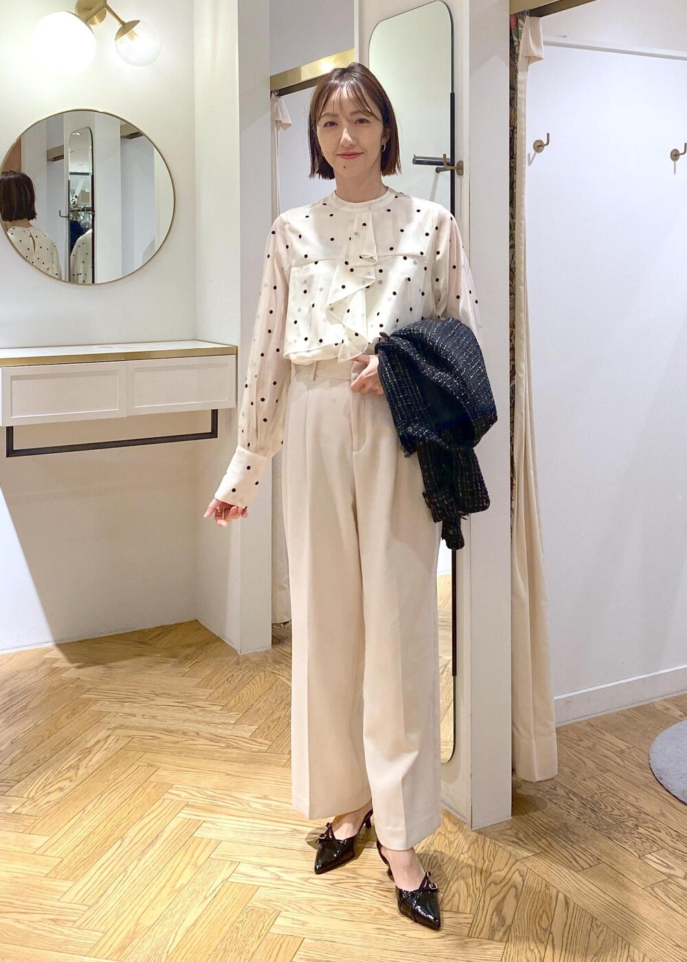 ブラック系のパンプス、ベージュ系のシャツ/ブラウス、ホワイト系のスラックスを着用したレディースの冬コーディネートの9枚目の写真