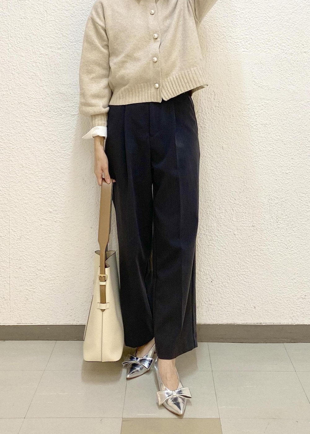 ベージュ系のカーディガン/ボレロ、グレー系のスラックス、ホワイト系のショルダーバッグを着用したレディースの冬コーディネートの3枚目の写真