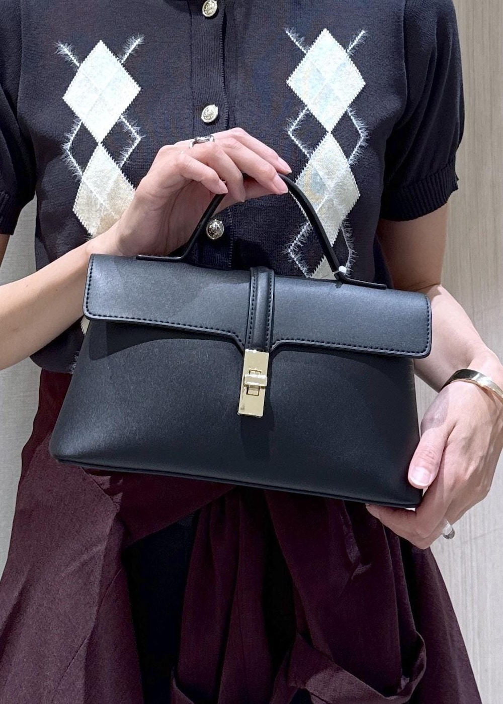 ブラック系のショルダーバッグ、ブラック系のパンプス、グレー系のカーディガン/ボレロを着用したレディースの夏コーディネートの9枚目の写真