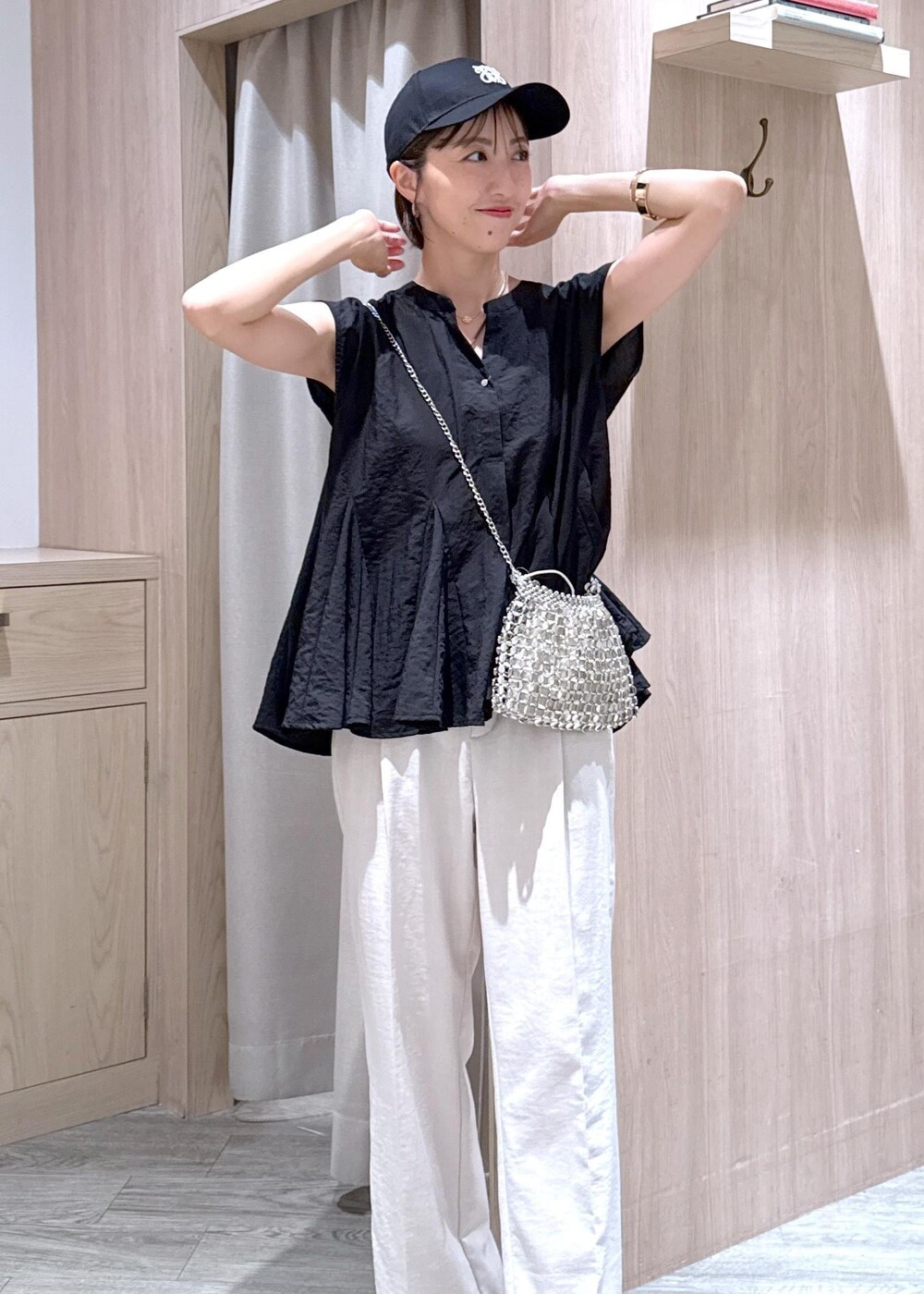 ブラック系のサンダル、ブラック系のシャツ/ブラウス、ホワイト系のスラックスを着用したレディースの夏コーディネートの7枚目の写真