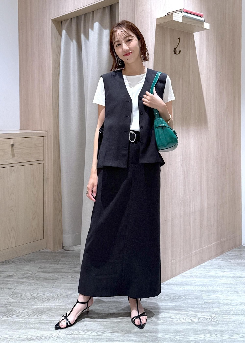 ブラック系のサンダル、グレー系のスカート、ホワイト系のTシャツ/カットソーを着用したレディースの夏コーディネートの2枚目の写真