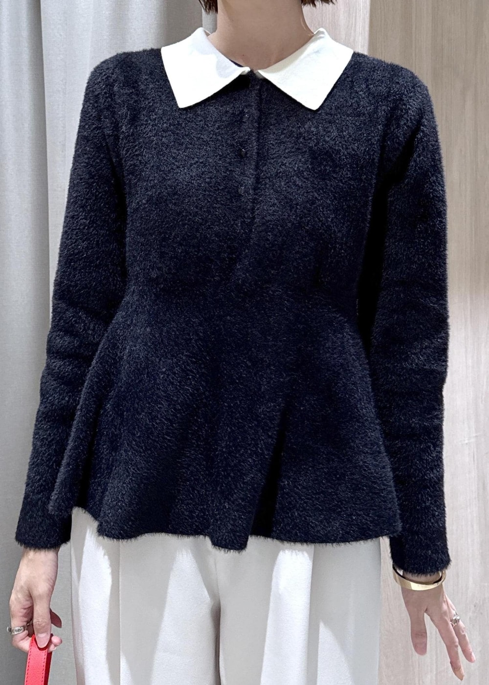 ブラック系のダウンジャケット/コート、ホワイト系のスラックス、ブラック系のニット/セーターを着用したレディースの冬コーディネートの6枚目の写真