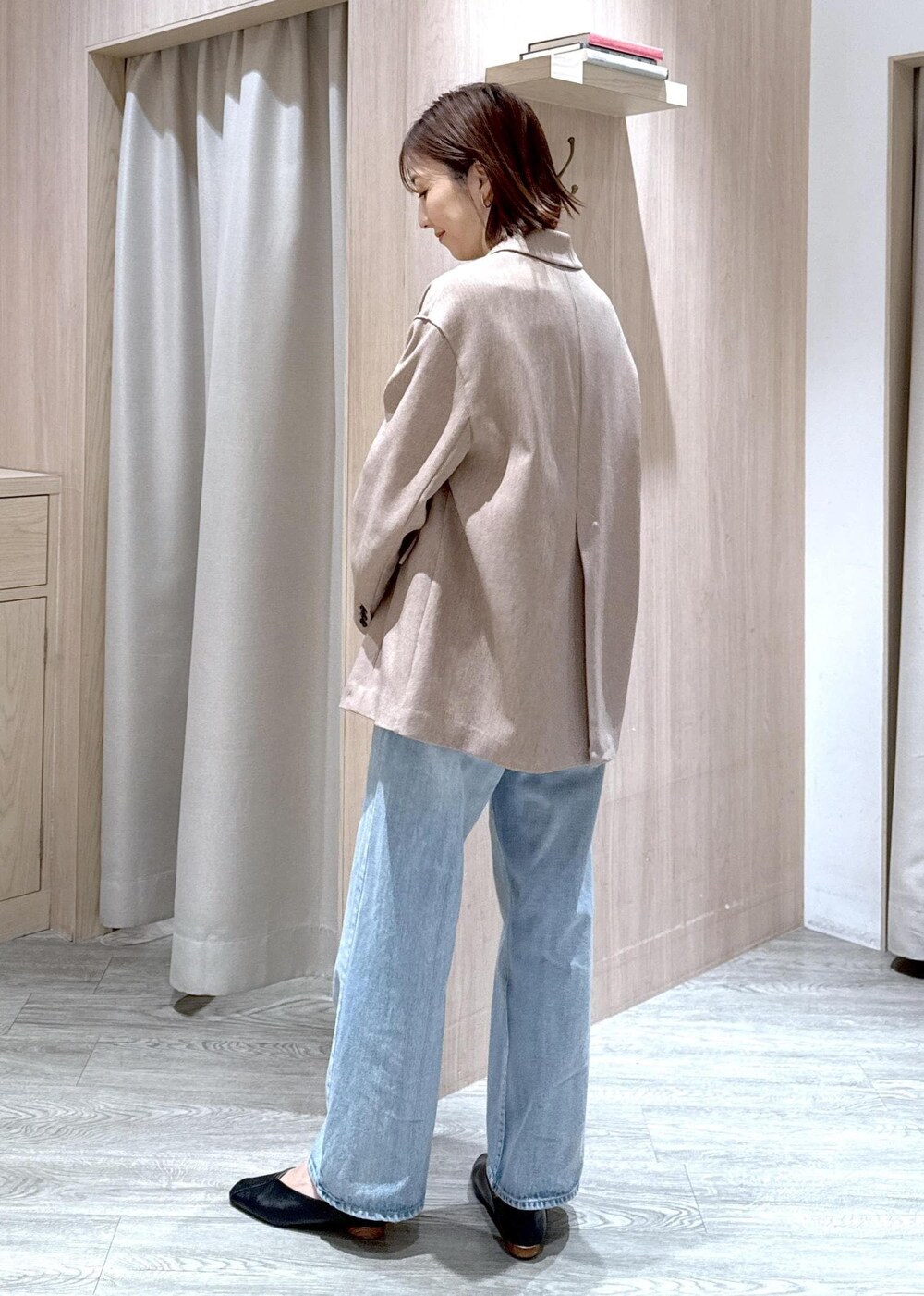 ブラック系のショルダーバッグ、ブルー系のデニムパンツ、イエロー系のテーラードジャケットを着用したレディースの春コーディネートの3枚目の写真