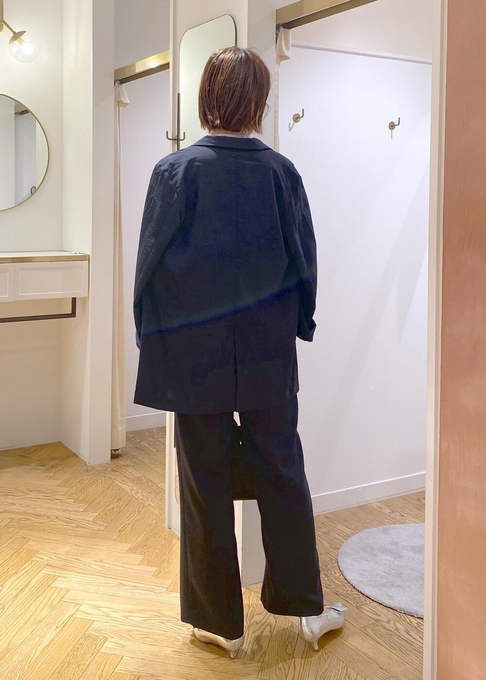 シルバー系のパンプス、ブルー系のスラックス、ブルー系のテーラードジャケットを着用したレディースの夏コーディネートの4枚目の写真