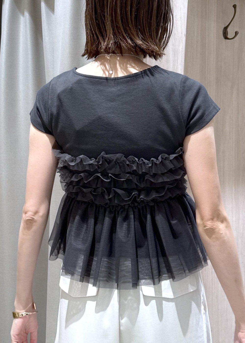 ブラック系のショルダーバッグ、ブラック系のパンプス、グレー系のTシャツ/カットソーを着用したレディースの夏コーディネートの9枚目の写真