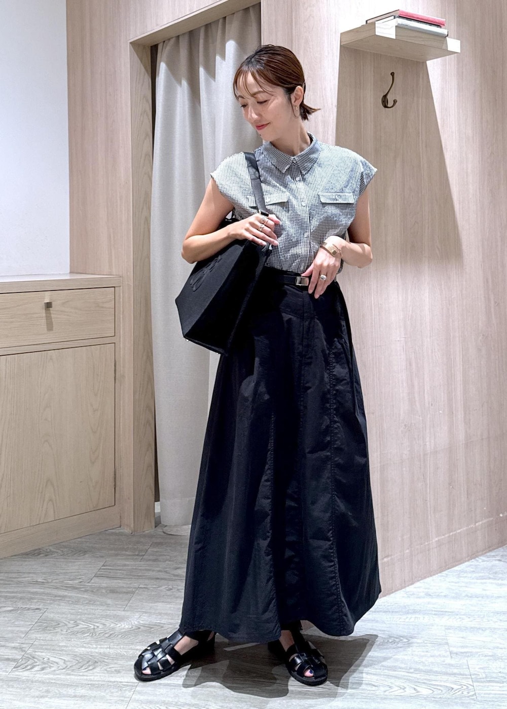 ブラック系のシャツ/ブラウス、ブラック系のトートバッグ、ブラック系のスカートを着用したレディースの夏コーディネートの2枚目の写真