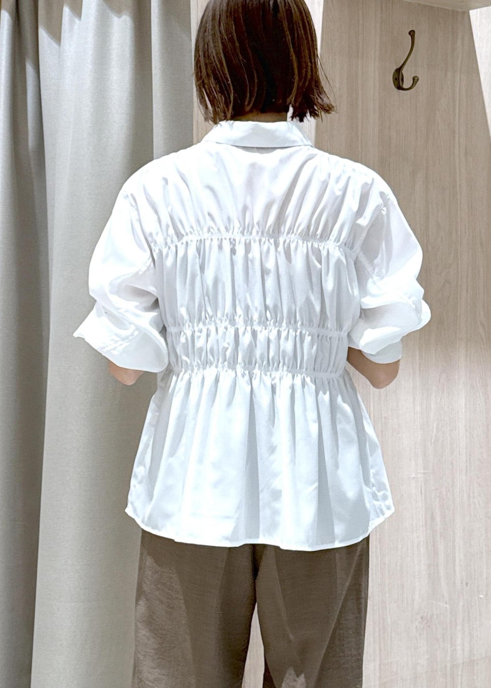 ホワイト系のシャツ/ブラウス、ブラック系のショルダーバッグ、グリーン系のスラックスを着用したレディースの春コーディネートの8枚目の写真