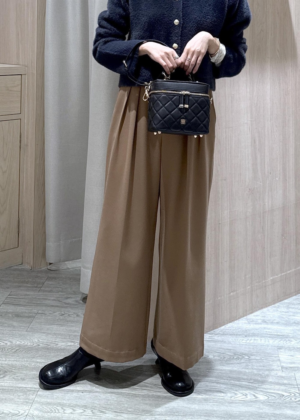 ブルー系のカーディガン/ボレロ、ホワイト系のTシャツ/カットソー、ブラック系のブーツを着用したレディースの冬コーディネートの6枚目の写真