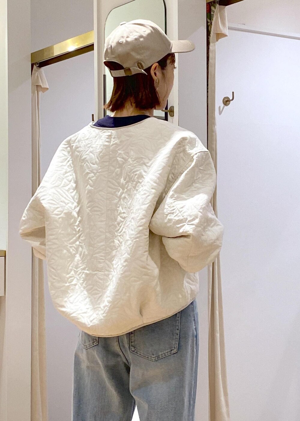 シルバー系のパンプス、ホワイト系のブルゾン、ブルー系のニット/セーターを着用したレディースの秋コーディネートの7枚目の写真