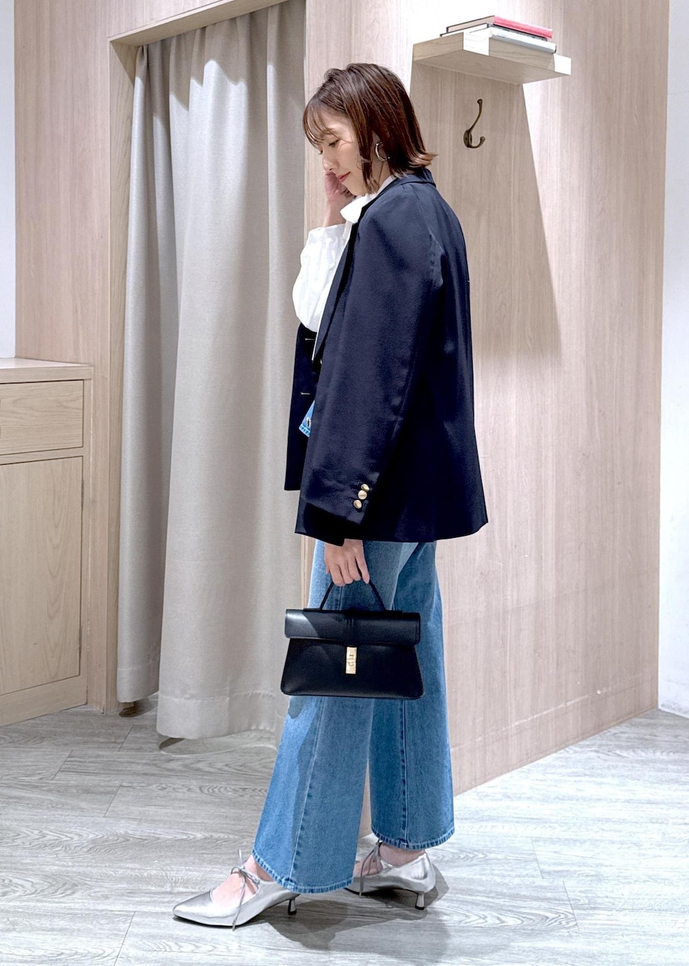 ブラック系のショルダーバッグ、ブルー系のキャミソール、ブルー系のテーラードジャケットを着用したレディースの冬コーディネートの3枚目の写真