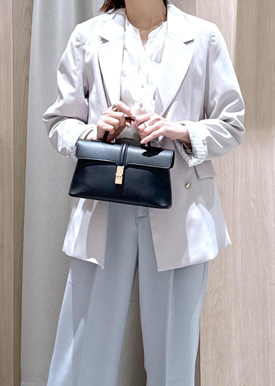 ブラック系のショルダーバッグ、ブルー系のスラックス、ベージュ系のテーラードジャケットを着用したレディースの春コーディネートの8枚目の写真