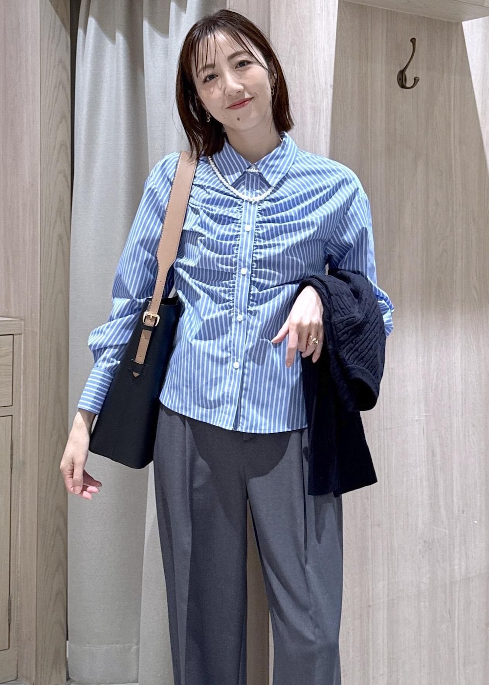 ブラック系のトートバッグ、ブルー系のカーディガン/ボレロ、グレー系のその他パンツを着用したレディースの冬コーディネートの10枚目の写真