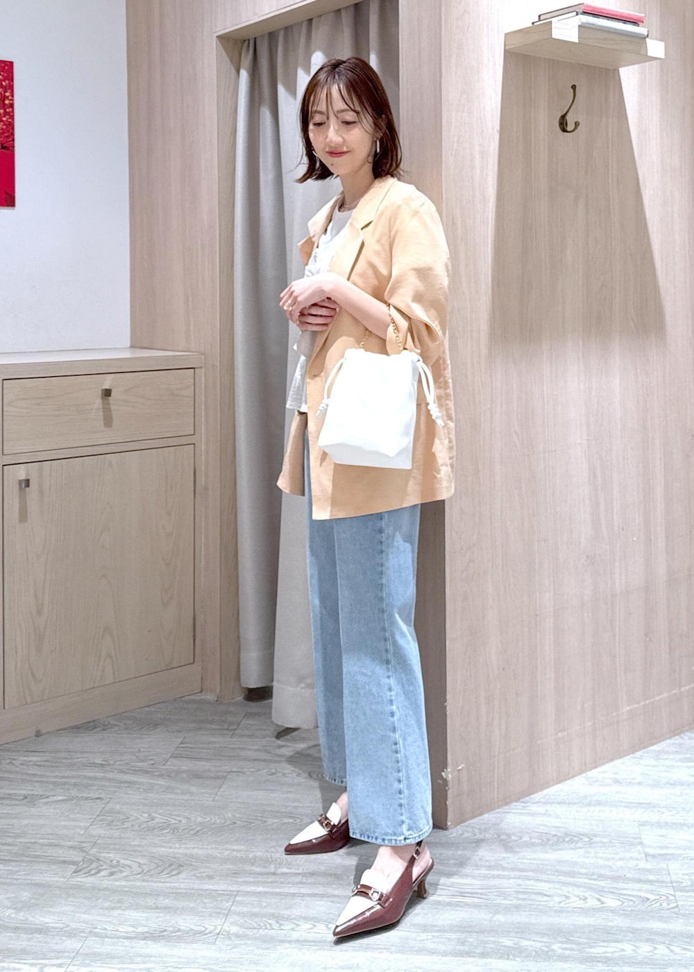 ブラウン系のパンプス、ホワイト系のTシャツ/カットソー、ブルー系のデニムパンツを着用したレディースの春コーディネートの2枚目の写真