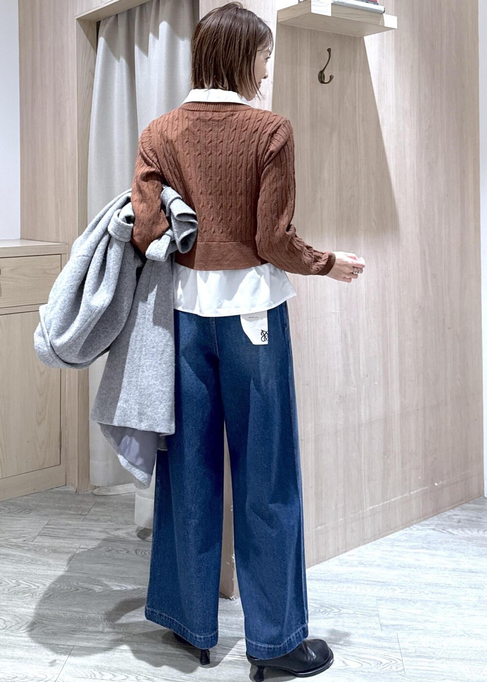 グレー系のその他アウター、ブラウン系のニット/セーター、ブルー系のデニムパンツを着用したレディースの冬コーディネートの6枚目の写真