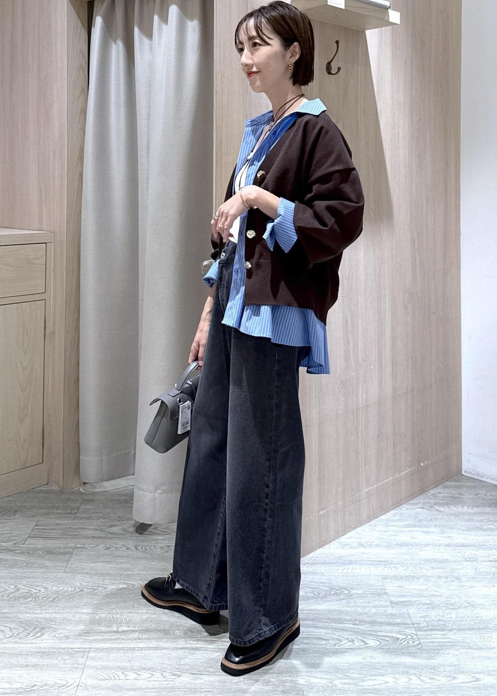 グレー系のショルダーバッグ、ブラック系のローファー、ホワイト系のキャミソールを着用したレディースの秋コーディネートの4枚目の写真