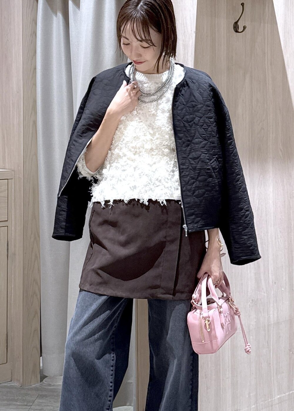 ピンク系のボストンバッグ、ブラック系のブーツ、ブラック系のブルゾンを着用したレディースの秋コーディネートの8枚目の写真