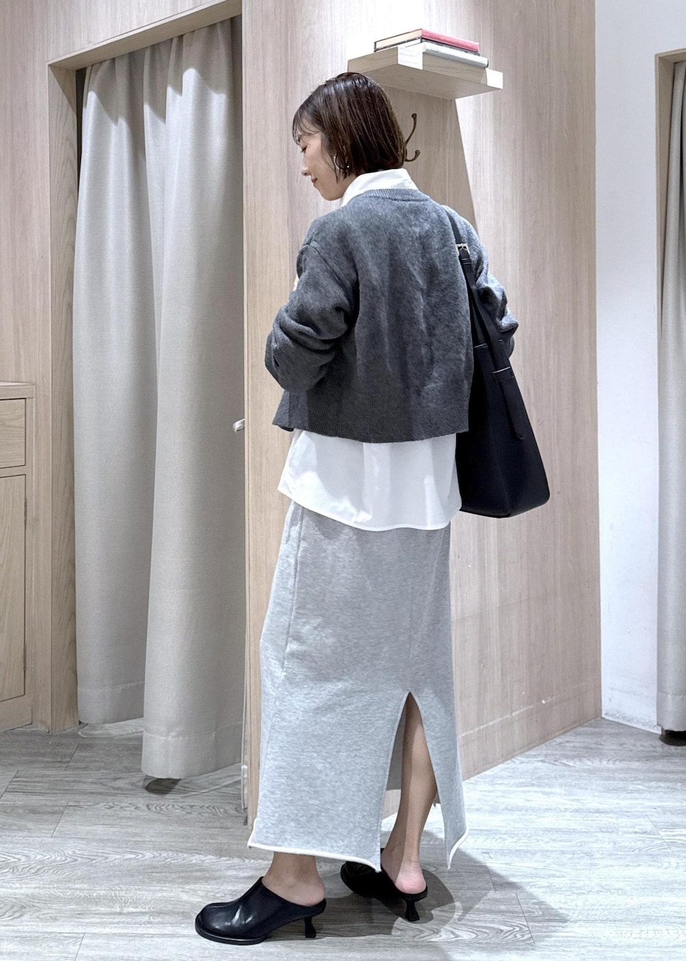 ブラック系のトートバッグ、グレー系のスカート、ホワイト系のシャツ/ブラウスを着用したレディースの秋コーディネートの3枚目の写真