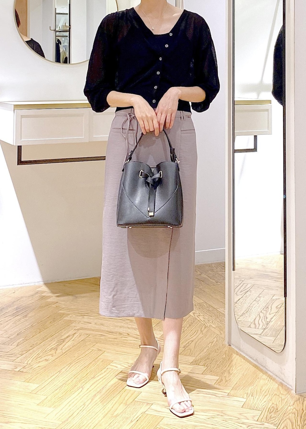 ブラック系のキャミソール、ブラック系のハンドバッグ、ホワイト系のサンダルを着用したレディースの夏コーディネートの4枚目の写真