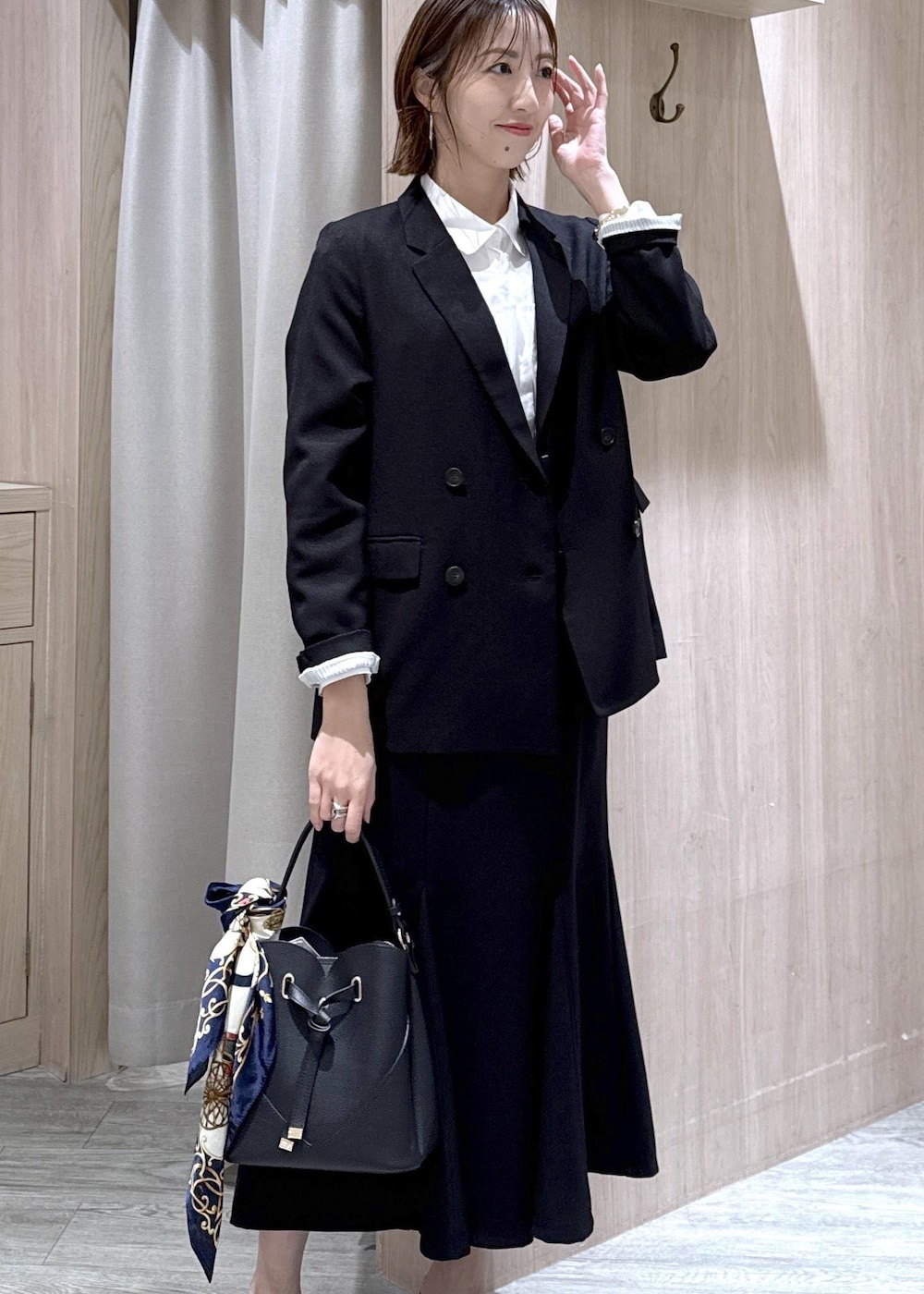 ブラック系のショルダーバッグ、ブラック系のスカート、ブラック系のテーラードジャケットを着用したレディースの冬コーディネートの7枚目の写真