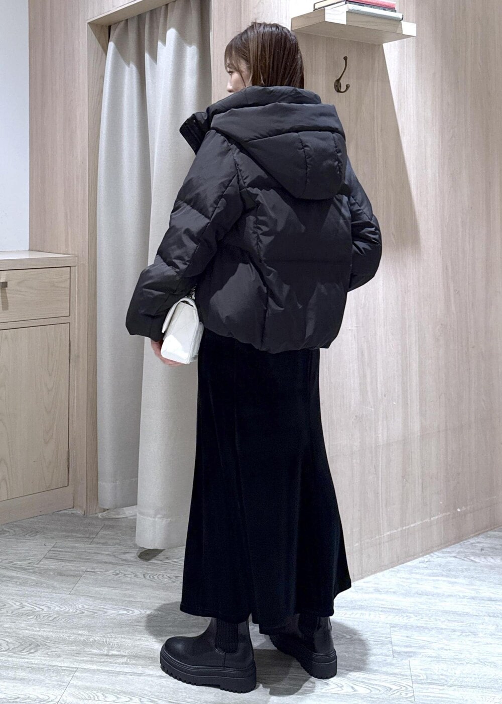 ブラック系のブーツ、ブラック系のスカート、ブラック系のダウンジャケット/コートを着用したレディースの冬コーディネートの3枚目の写真